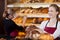 Saleswoman in bakery in front of shelves