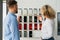 Saleswoman of the car dealership shows the customer samples of the color of car body.