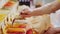 Saleswoman fills paper bag with ground paprika at store