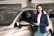 Saleswoman near new car in dealership