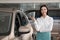 Saleswoman near new car in dealership