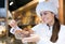 Saleswoman offering bread and different pastry for sale