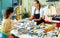 saleswoman offering fresh whole sea bass to buyer