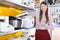 Saleswoman offering multicooker in household appliances shop