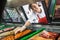 Saleswoman Picking Meat Displayed In Cabinet