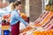 Saleswoman selecting fresh fruit and preparing for working day in fruitshop.