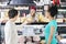 Saleswoman Selling Cheese To Couple In Grocery Store