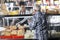 Saleswoman Selling Cheese To Senior Man At Shop