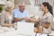 Saleswoman Shaking Hands With Senior Couple