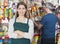 Saleswoman Standing Arms Crossed While Customer Selecting Produc