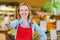 Saleswoman in supermarket holding thumbs up