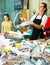 Saleswoman weighing fresh shrimps on scales