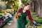 Saleswoman working in garden shop, examining and preparing for sale potted plants