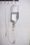 Saline solution iv bag with syringe line hanging on wall