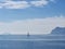 Saling boat at the berth in the Norwegian fjord on a background of blue sky and sea landscape