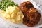 Salisbury steak with mashed potatoes and green peas close-up on