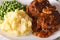 Salisbury steak with mashed potatoes and green peas close-up. Ho