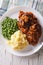 Salisbury steak with potatoes and green peas close-up. vertical