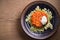 Salmon burger and cabbage salad in bowl on wooden table. Salmon fish cake and vegetables.