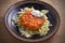 Salmon burger and cabbage salad in bowl on wooden table. Salmon fish cake and vegetables.