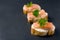Salmon canape sandwiches with baguette on black grunge background.