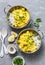 Salmon curry and rice in curry dishes on grey background, top view. Indian cusine style