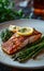 salmon fillet with a crispy skin, served with roasted asparagus spears and lemon