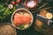 Salmon fillet and lemon slices in bamboo steamer on dark rustic kitchen table with ingredients and tools. Healthy eating and