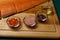 salmon fillet, pink salt, oil, colorful pepper and dried carrots in glass bowls