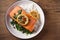 Salmon fillet with rice and spinach garnish. Fish steak. Lemon salmon on white plate on wooden background