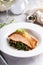 Salmon fillet served with sauteed greens and mushrooms