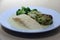 Salmon Fillet with vegetable medallions, mixed vegetable, green broccoli, lemon and dill sauce in the white dish.