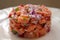 Salmon fish ceviche cooking ring serving on white plate close up. Traditional Peruvian dish