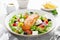 Salmon fish salad. Fresh vegetable greek salad with tomato, pepper, lettuce, olives, cucumbers, feta cheese and grilled salmon