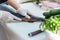 The salmon is in the hands of the experienced  chef. She is using a knife to slice salmon fillet for sashimi and sushi. A chef cut