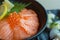 A salmon ikura don in black bowl image close up in japanese rest