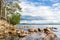Salmon lake of Karelia with trees and stone rock shoreline on the summer day.