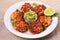 Salmon patties or cakes, lime and avocado on white plate. Fritters of fish. Salmon burgers