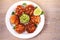 Salmon patties or cakes, lime and avocado on white plate. Fritters of fish. Salmon burgers