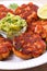 Salmon patties or cakes, lime and avocado on white plate. Fritters of fish. Salmon burgers