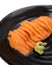 Salmon raw sashimi on black ceramic plate with selected focus