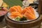 Salmon raw sashimi decorate on ice and wooden basket plate in japanese restaurant style.selective focus