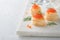 Salmon red caviar toast. Christmas canape or toast with red caviar on white plate on light background. Idea to xmas snack