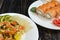 Salmon with rice and vegetables on a white plate of sushi with salmon on a dark background close-up view from the top side