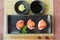 Salmon Roe on Hamachi sushi on black plate along with Japanese s