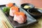 Salmon Roe on Hamachi sushi on black plate along with Japanese s