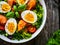 Salmon salad - smoked salmon hard boiled eggs and green vegetables on wooden table