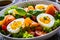 Salmon salad - smoked salmon hard boiled eggs and green vegetables on wooden table