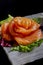 Salmon sashimi decorated in flower. Vertical image. Dark food