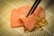 Salmon Sashimi mixed with Fish oil capsules with chopstick grab